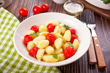 Homemade Italian gnocchi with tomato cherry on the wooden table