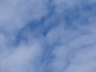 The blue sky is covered with light, white, fluffy clouds.