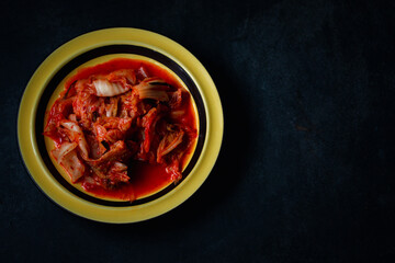 Lettuce kimchi in yellow plate on black background Flat lay copy space