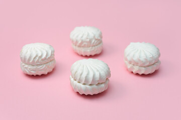 laying out round white marshmallows. pink background