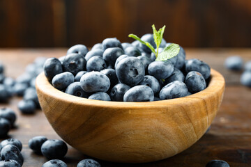 Juicy and fresh blueberries with green leaves on a rustic table. Vegan and vegetarian concept.
