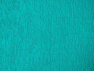Abstract rough wall texture plaster turquoise color. Grunge scratched surface background.