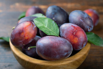 Sweet Plums in a plate  on a wooden  table.