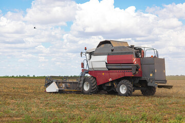 A large combine works in a wheat field