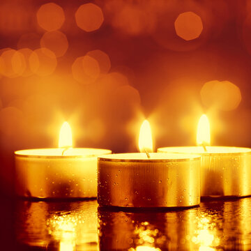 Holiday lights. Abstract backgrounds with burning candle and beautiful bokeh
