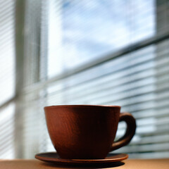 Morning coffee. Cup and plate close to window, under the sunlight