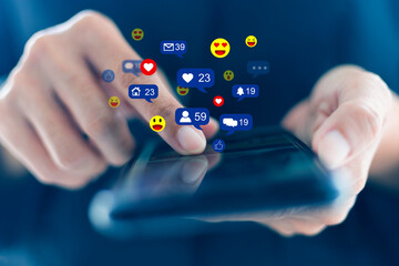 Close-up hands holding and touch screen to communicate with others through emoji in a soft blur using the smart phone social media concept