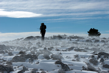 Mountaineer in the middle of a winter blizzard, on the rope of Las Cabras Las Cabras mountain range, on a clear day.