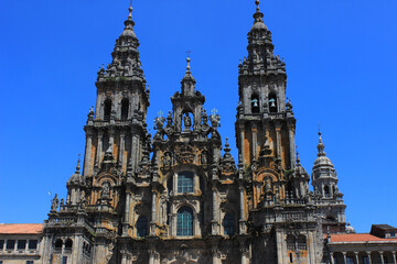 Fototapeta premium Main facade of the cathedral of Santiago de Compostela, from the Obradoiro square, under the blue sky.
