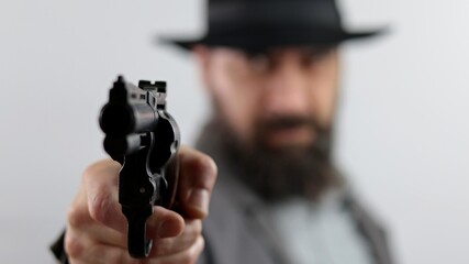 Bandit, gangster or detective pointing gun at the camera, isolated on white background.
