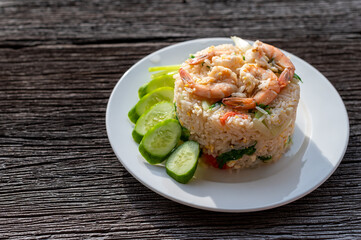 Thai fried rice with prawns and vegetables on wooden table