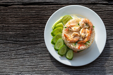 Thai fried rice with prawns and vegetables on wooden table
