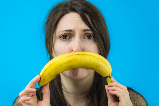 Viso triste di una giovane e bella ragazza con una banana 
