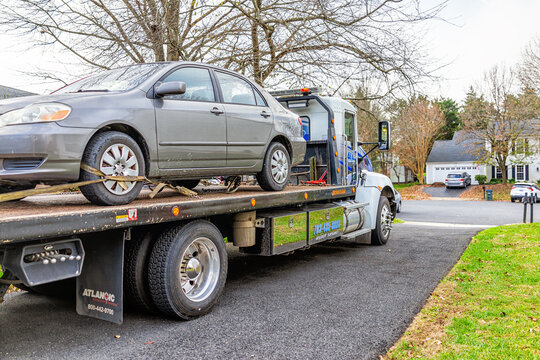 Herndon, USA - November 21, 2020: Car in driveway with tower tow vehicle truck due to fuel leak trouble damage safety in Virginia neighborhood residential