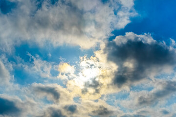 The rays of the sun break through the clouds.Blue sky with white feather clouds. Panoramic view of...