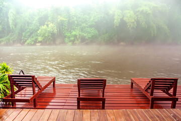 three red lounge chairs standing on the platform with beautiful view on a jungle river