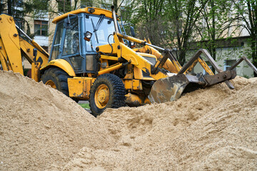 Obraz na płótnie Canvas tractor or bulldozer works with a pile of sand for construction
