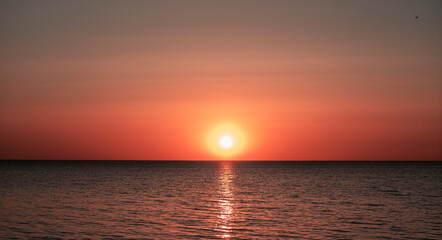 Obraz premium sunset by the sea, almost set sun by the sea