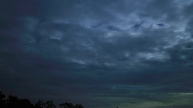 Dark clouds moving against full moon in night sky, time lapse