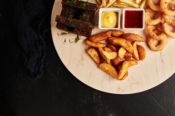 tackler with snacks on black textured background top view