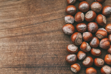 A whole hazelnut lies on a wooden table. Copy space