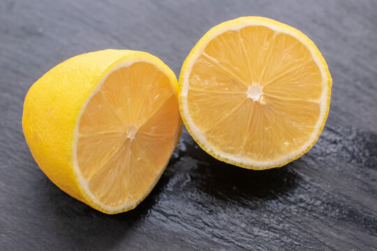 Juicy fresh lemon on a black stone background. Gastronomic concept.