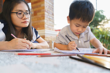 Asian boy drawing and painting with his mother