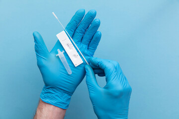Doctor in blue gloves using a lateral flow covid-19 testing kit - obrazy, fototapety, plakaty