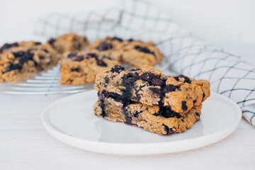 Homemade oatmeal scones with berries on white plate. Vegan sweet baked food. Gluten free pastry.