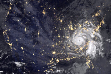Huge hurricane over America, night photography. Lights of night cities and the eyes of the hurricane are clearly visible. Collage with abstract hurricane. Elements of this image furnished by NASA.