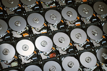 wallpaper of numbers of hard drives show inside metal disk and parts in pattern texture in cool blue tone light and shade
