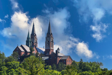 old historic church with twin steeples on a high hill mountain with dramatic sky shot from a...
