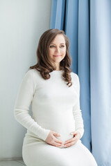 Cute pregnant woman dreaming on white background