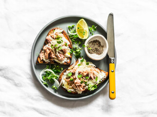 Sandwiches with smoked mackerel, cottage cheese and microgreens - delicious snack, appetizer, tapas, breakfast on a light background, top view