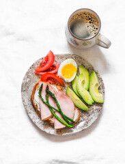 Delicious brunch, breakfast, snack - coffee, sandwich with cottage cheese, ham, asparagus, avocado, boiled egg, tomato on a light background, top view