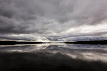 Dramatic autumn clouds reflection in Muonio lake, Lapland, Northern Finland