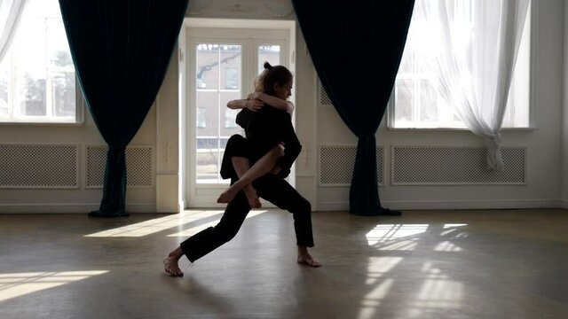 amazing shot of two contemporary dancers in hall, young man and woman are dancing passionately