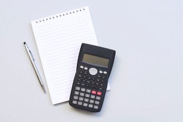 Top view of office desk with pen, notepad and calculator