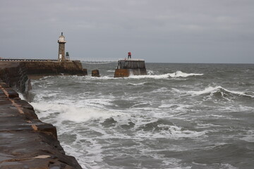 Whitby harbour England battered by rough seas

