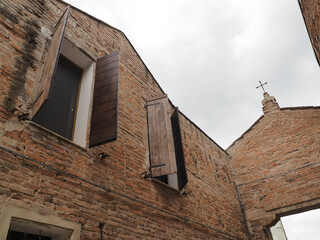 Fototapeta na wymiar Ferrara, Italy. Sant'Antonio in Polesine Monastery, entrance detail. Open windows and crucifix.
