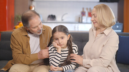 The grandfather and grandmother who support, talk to her and try to make her anxious, sad little...