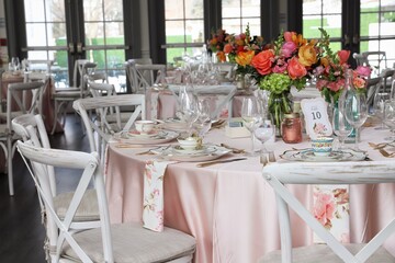 Table set up for bridal shower on bright spring day with flowers in the middle and vintage tea cups...