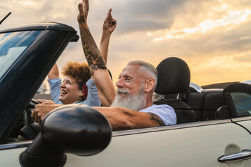 Happy senior couple having fun driving on new convertible car - Mature people enjoying time...