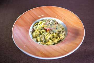 pasta with cheese and tomato in an orange plate