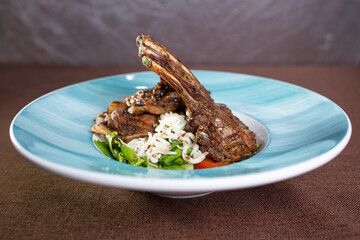 a dish in a restaurant braised lamb rib with fresh salad on a plate