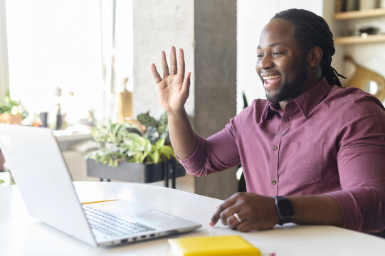 Stay In Touch With Work Team During Quarantine. African-American Guy Using Laptop For Video Connection, Waving Hi Into Webcam, Involved Video Meeting With Colleagues, Greeting Participants Online