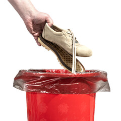 A man throws out old shoes with the soles that have been torn off, into the trash can. Male hand throws out worn out shoes in the trash isolated on white background close up.