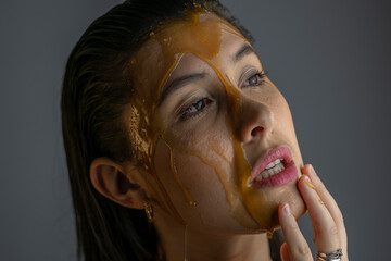black haired woman with honey on her face