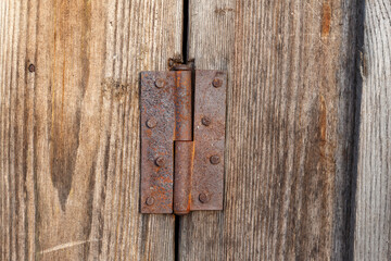 Old rusty metal door hinge. Door hinge on a wooden door.