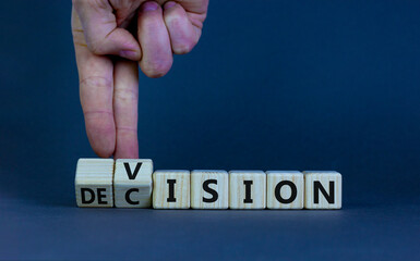Vision and decision symbol. Businessman turns wooden cubes and changes the word 'decision' to...